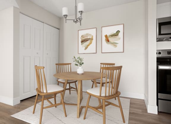 a dining room with a table and chairs and two paintings on the wall